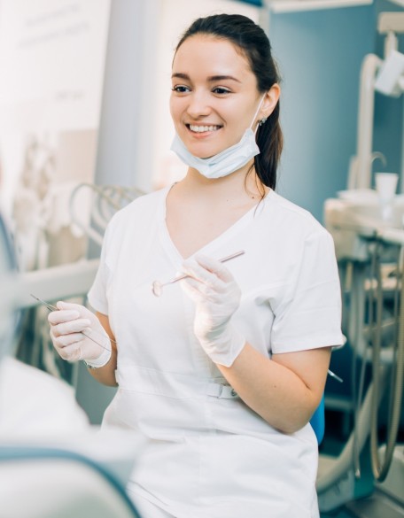 Junge Zahnarzthelferin behandelt Patient