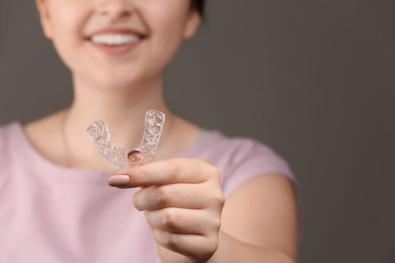Junge Frau hält Aligner
