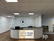 Anmeldungsthresen mit Leuchtschild "Gerade Zähne, Gerade jetzt"